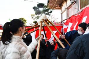 ついた餅を高く上に掲げる子どもたち