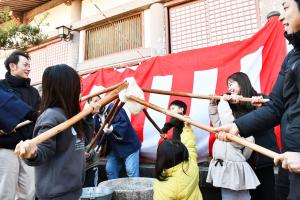 ついた餅を高く上に掲げる子どもたち