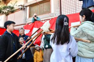 ついた餅を高く上に掲げる子どもたち