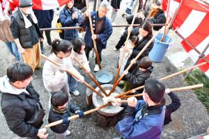 臼を囲んで餅をつく子どもたち