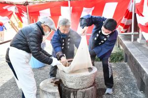 もち米を臼に入れる男性たち