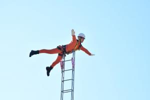 梯子の上でポーズを決める消防職員