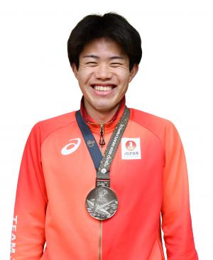 銀メダルを首にかけた笑顔の男性