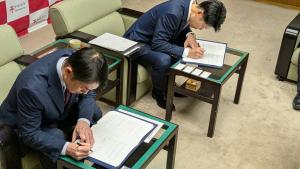 2人が署名する姿