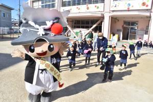 鬼のお面をつけたちきりくんに豆をぶつける園児たち