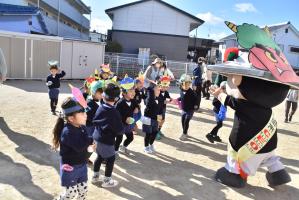 鬼のお面をつけたちきりくんに豆をぶつける園児たち