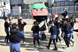 鬼のお面をつけたちきりくんに豆をぶつける園児たち