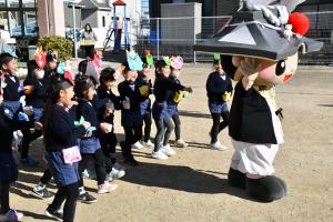 ちきりくんに豆をぶつける園児たち