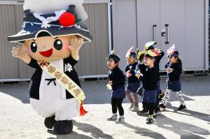 ちきりくんに豆をぶつける園児たち