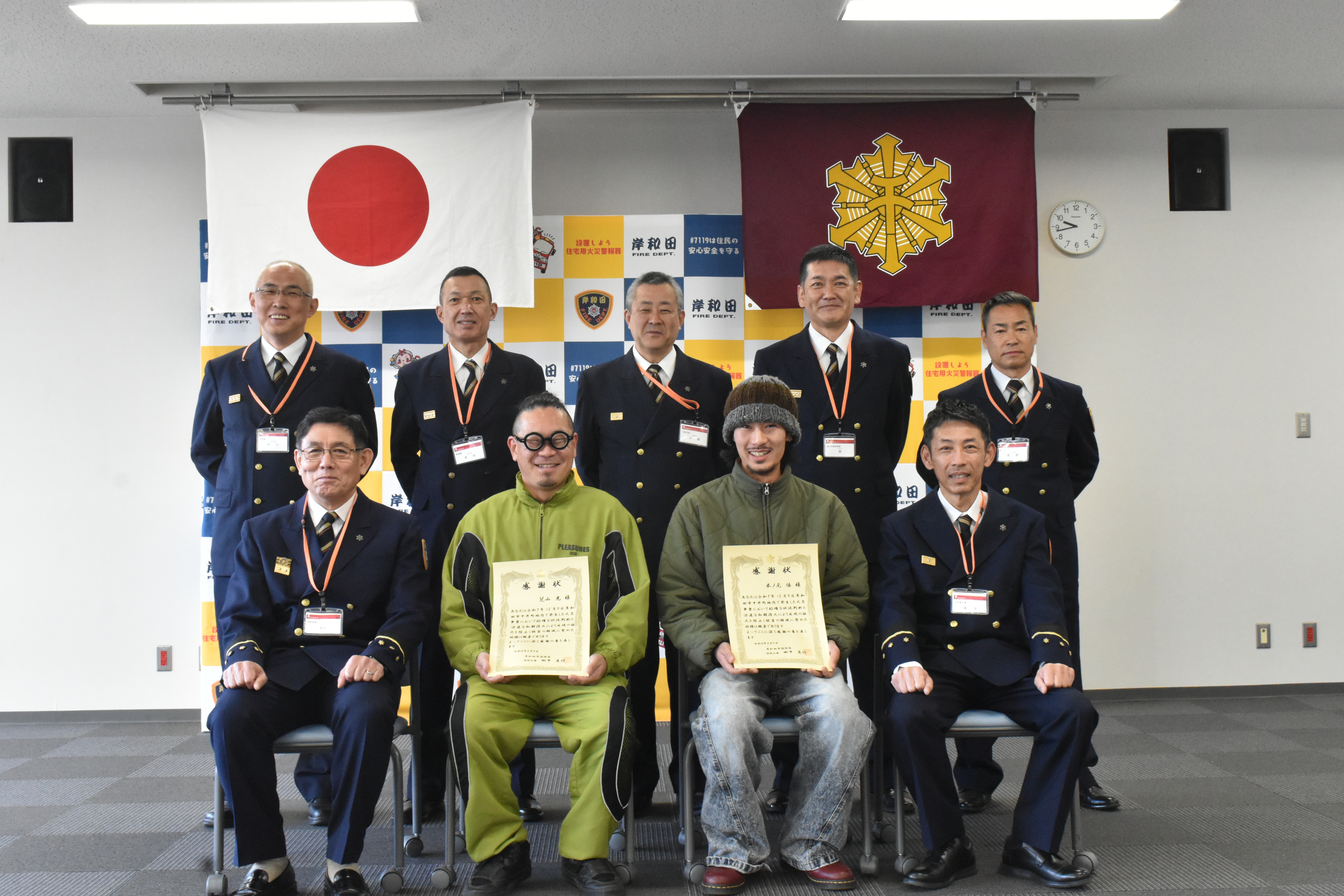 被表彰者と消防長と各課長が集まって合計9人で記念撮影