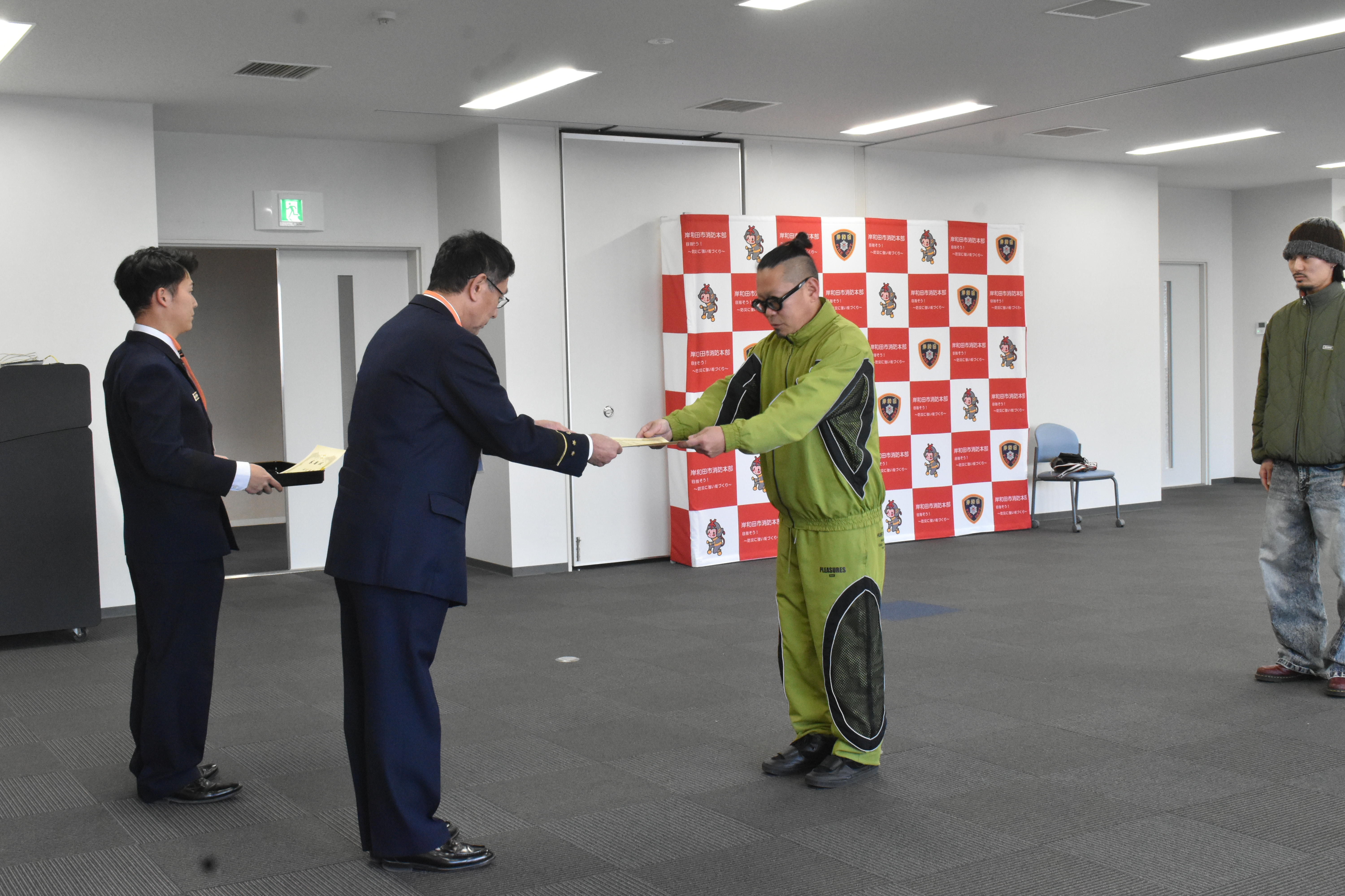 兒山さんが消防長から感謝状を受け取っている写真