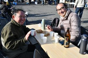 美味しそうに牡蠣料理を食べる笑顔の男性二人