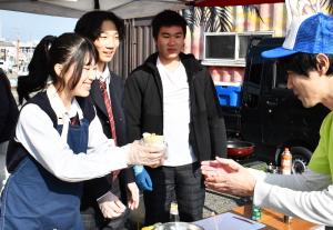 商品を手渡す産業高校の女子生徒