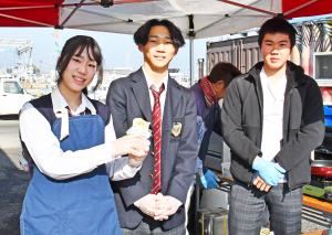 商品を持って笑う産業高校の女子生徒と男子生徒2人