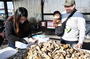 牡蠣の詰め放題をする親子