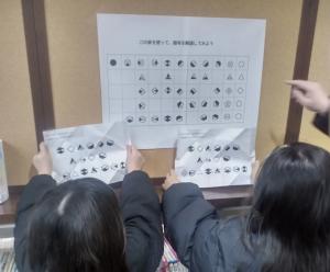 掲示しているクイズを見て考えている人たちの様子