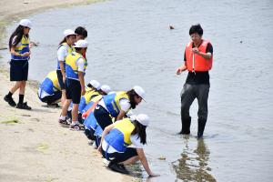 人工干潟で説明を聞く児童たち