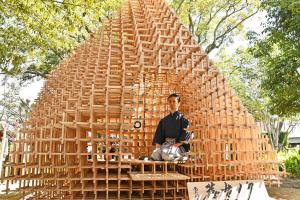 竹の茶室内に座る袴姿の男性