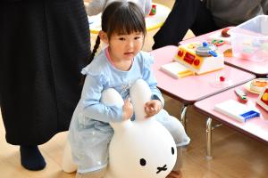 ウサギのおもちゃにまたがる女の子