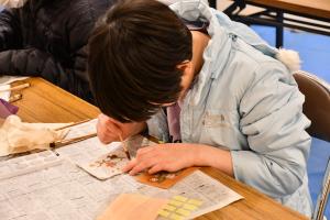 ベンガラ染めでコースターに模様をつける男の子