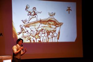 スクリーンに映し出されただんじりの絵と説明するkoheiさん