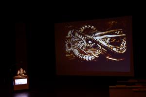 パフォーマンスをするkoheiさんとスクリーンに映る龍