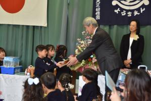 教育長へ小太鼓を渡す園児