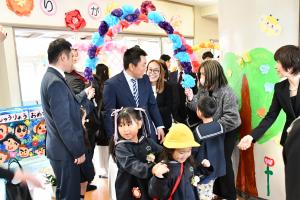 花飾りのアーケードを進む家族