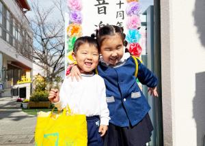 幼稚園児の姉弟（姉が弟の肩を組んでいる）