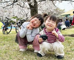 桜の木の下で笑顔の姉妹