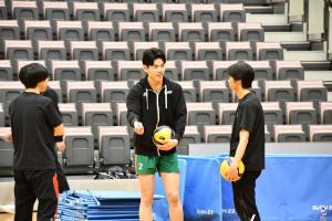 レシーブの受け方を教えてもらっている高校生