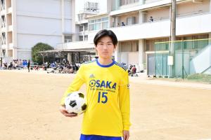 黄色のユニフォームを着てボールを持つ山内さん