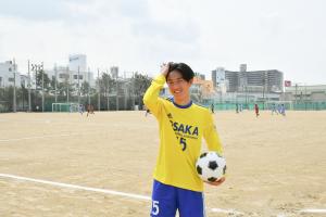 黄色のユニフォームを着てボールを持つ山内さん