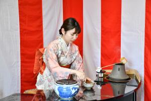お茶をたてる着物姿の女性