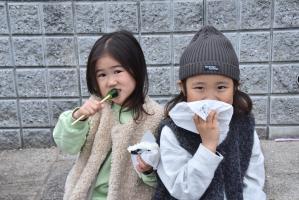 美味しそうに屋台の食べ物を食べる女の子二人