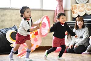 こいのぼりを持って走る園児