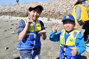 ピースサインをする小学生の姉弟