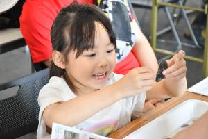 貝を持って笑顔の女の子