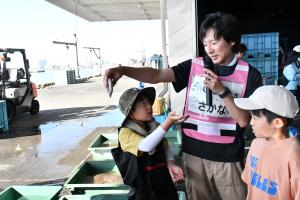 先生から魚の説明を聞く子どもたち