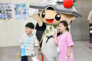 ちきりくんと記念写真を撮る小学生の男の子と女の子