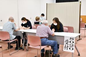 8020運動の受け付けをする高齢男性