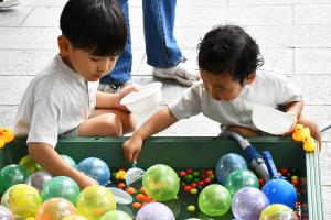 スーパーボールすくいをする幼い兄弟