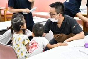 健診のブースで先生に歯を診てもらう女の子