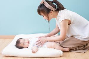 赤ちゃんの体をマッサージするお母さん