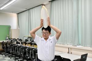 コウイカの甲羅を頭の上で持つ男子児童
