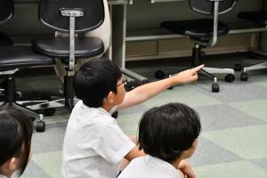 映像を見て指を指す男子児童