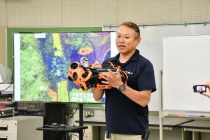 水中ドローンを持って説明する松本さん