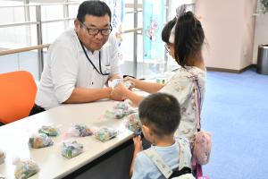 人工シーガラスを受け取る幼い姉弟