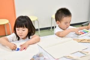 エコバッグに絵を描く幼い姉弟