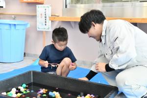 光る金魚すくいをする男の子
